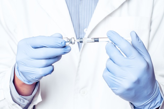 Врач набирает лекарство из флакона